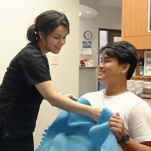 Team member giving dental patient a blanket