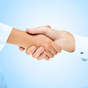 Close up of patient shaking dentist’s hand