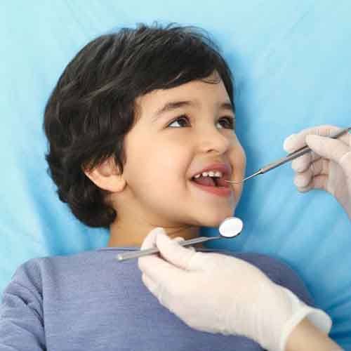 Beautiful, smiling little girl in dental treatment chair